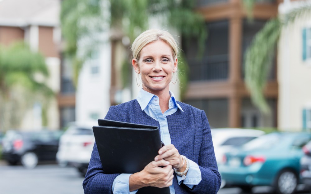 Businesswoman Standing Outside Building In Parking Lot