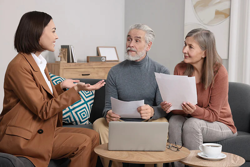 real estate agent consulting elderly couple about their homes to buy